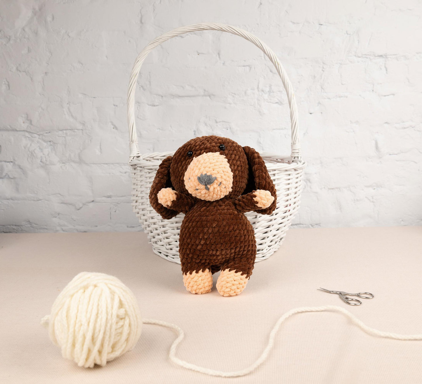 a stuffed monkey sitting next to a ball of yarn