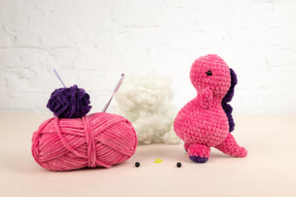 a pink ball of yarn next to a pink ball of yarn