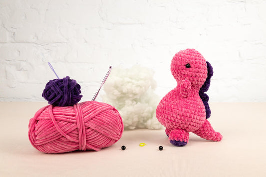 a pink ball of yarn next to a pink ball of yarn