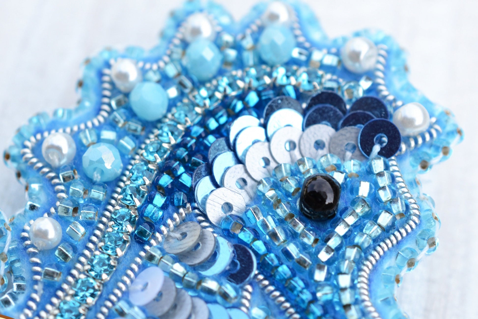 a close up of a blue beaded brooch