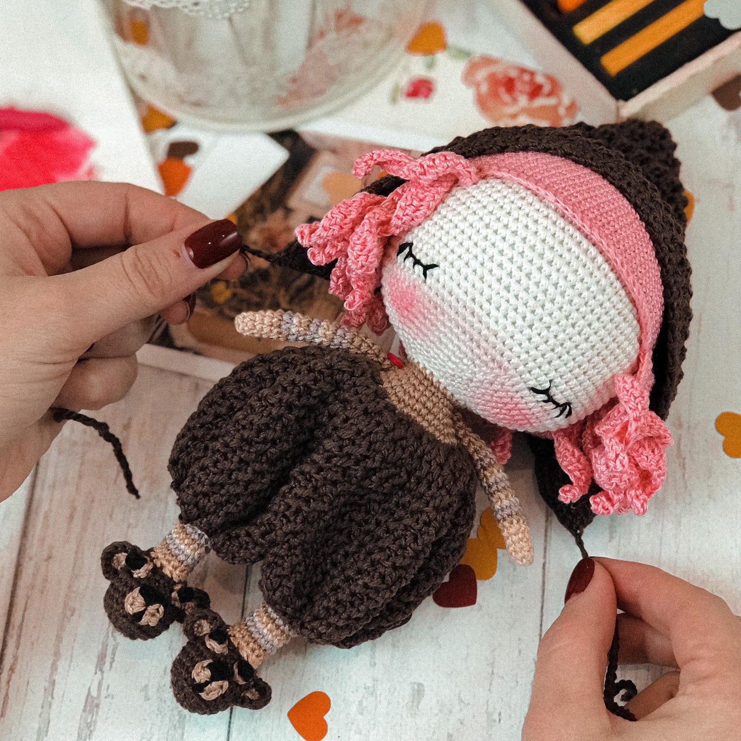 a person is holding a doll on a table