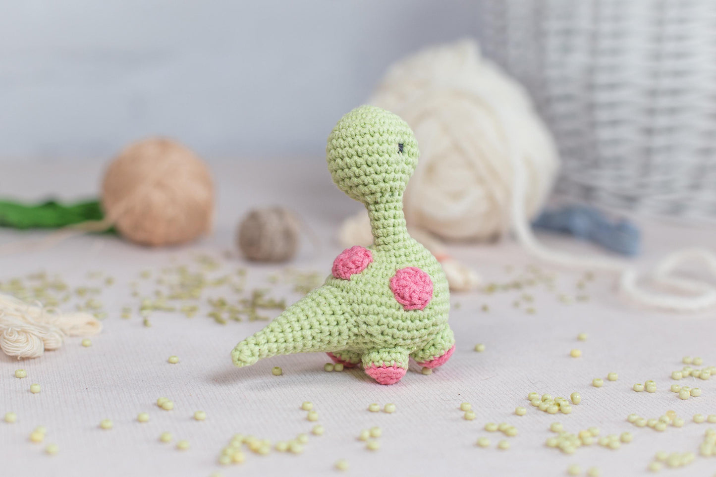 a crocheted toy of a dinosaur sitting on a table