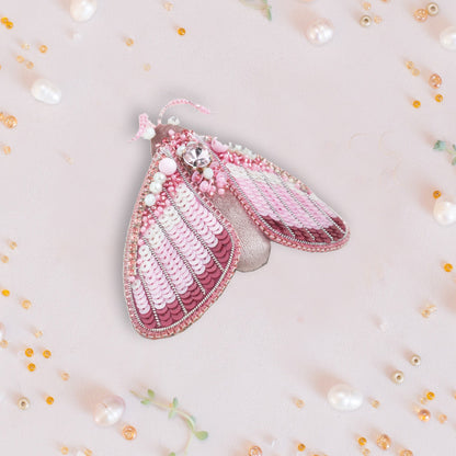 a close up of a pink purse with pearls