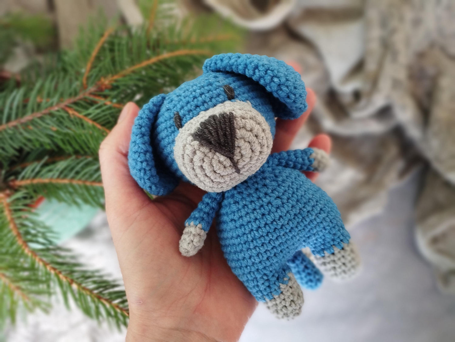 a hand holding a small crocheted stuffed animal