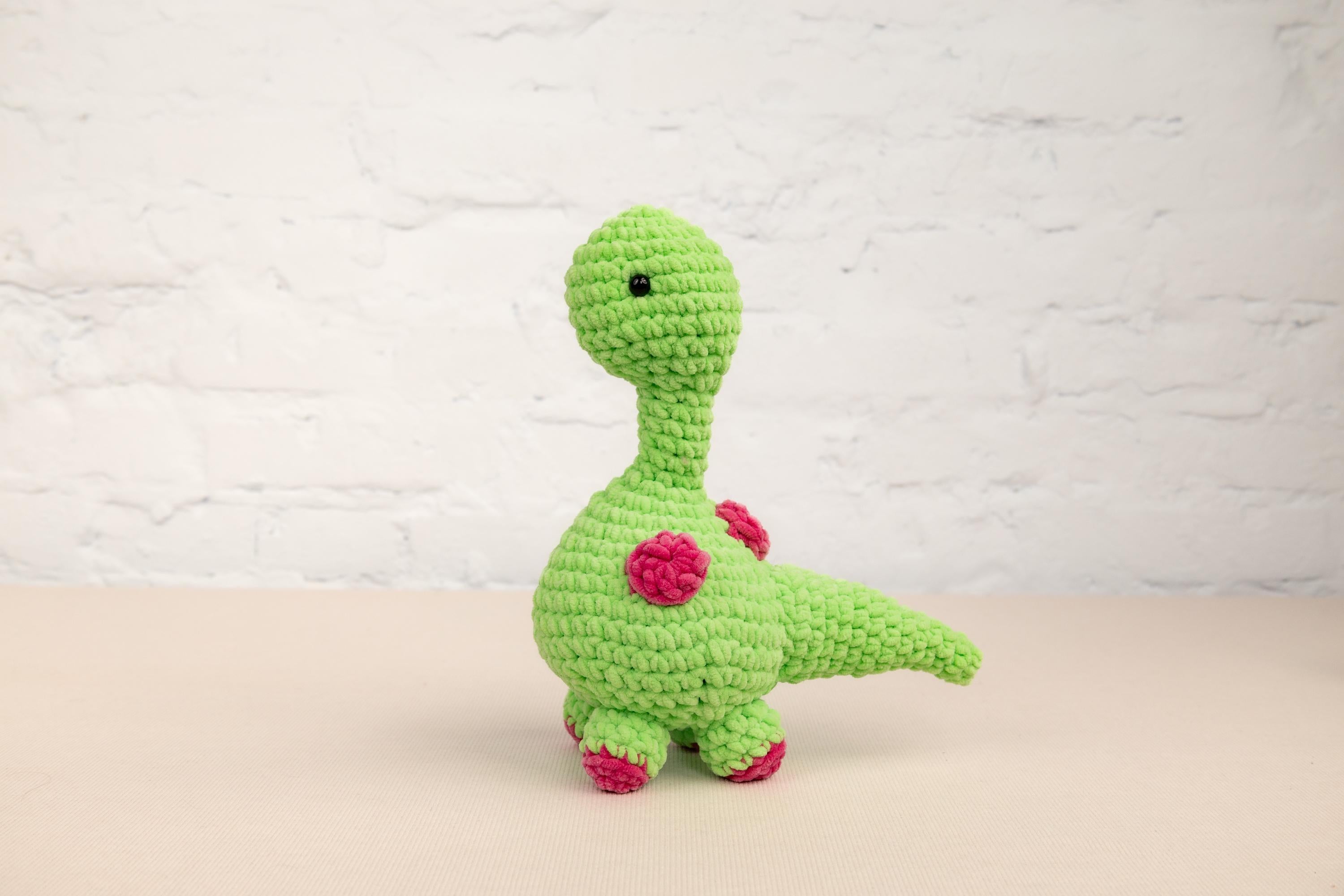 a green crocheted toy sitting on top of a table