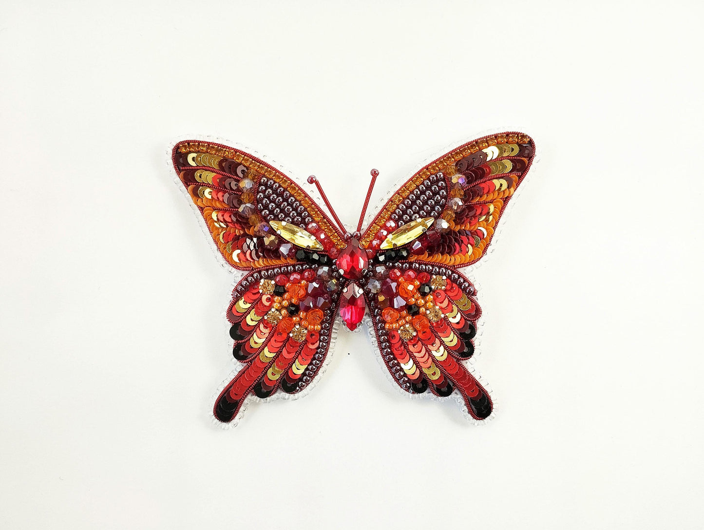 a colorful butterfly made out of beads on a white background