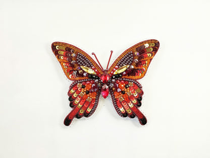 a colorful butterfly made out of beads on a white background