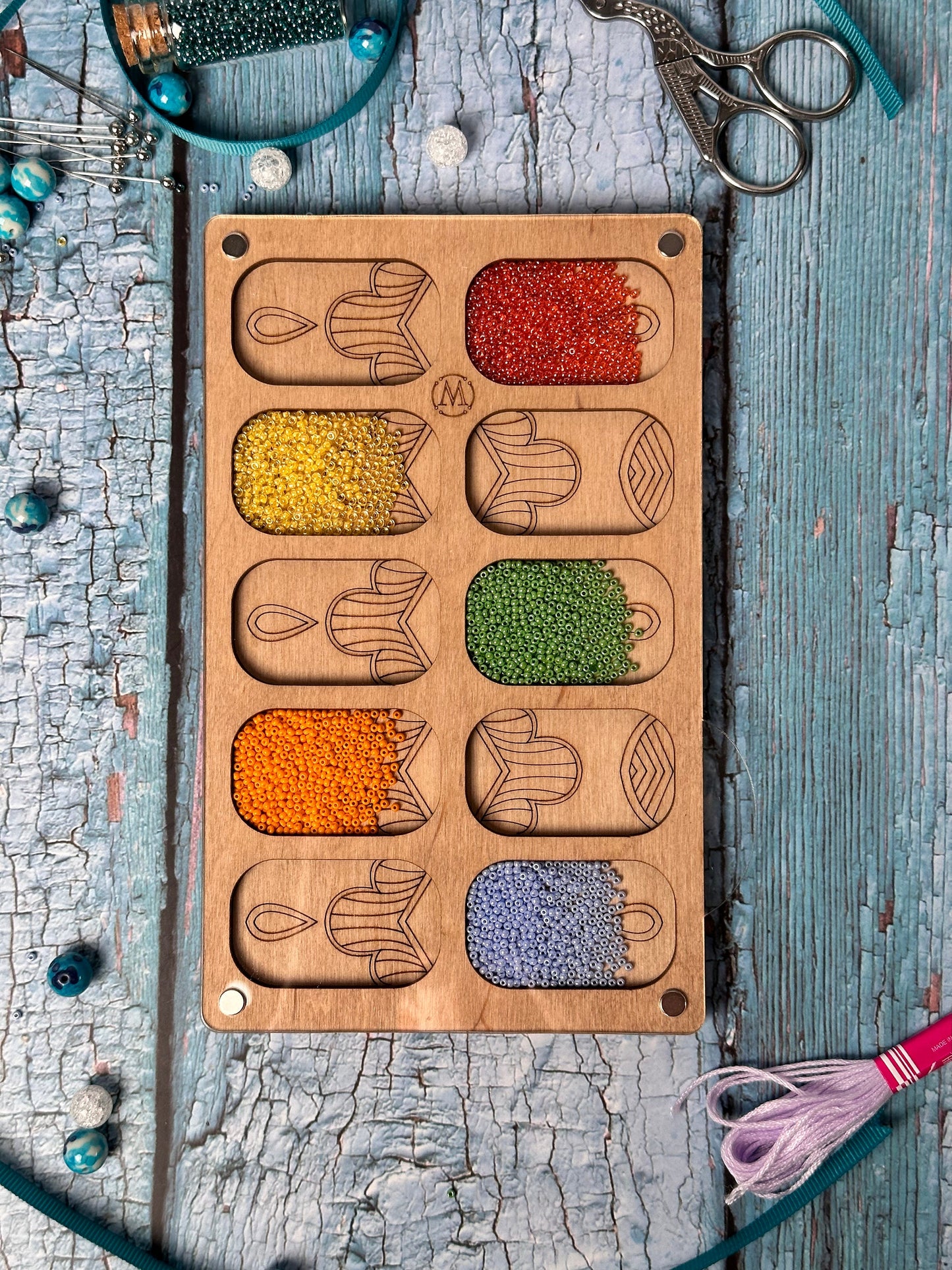 a wooden tray filled with different types of beads