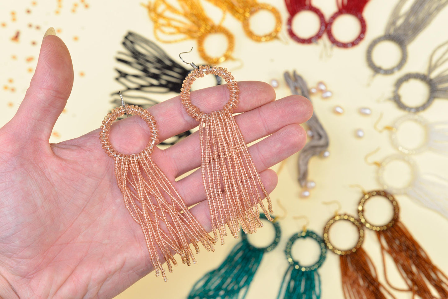 a hand is holding a pair of earrings