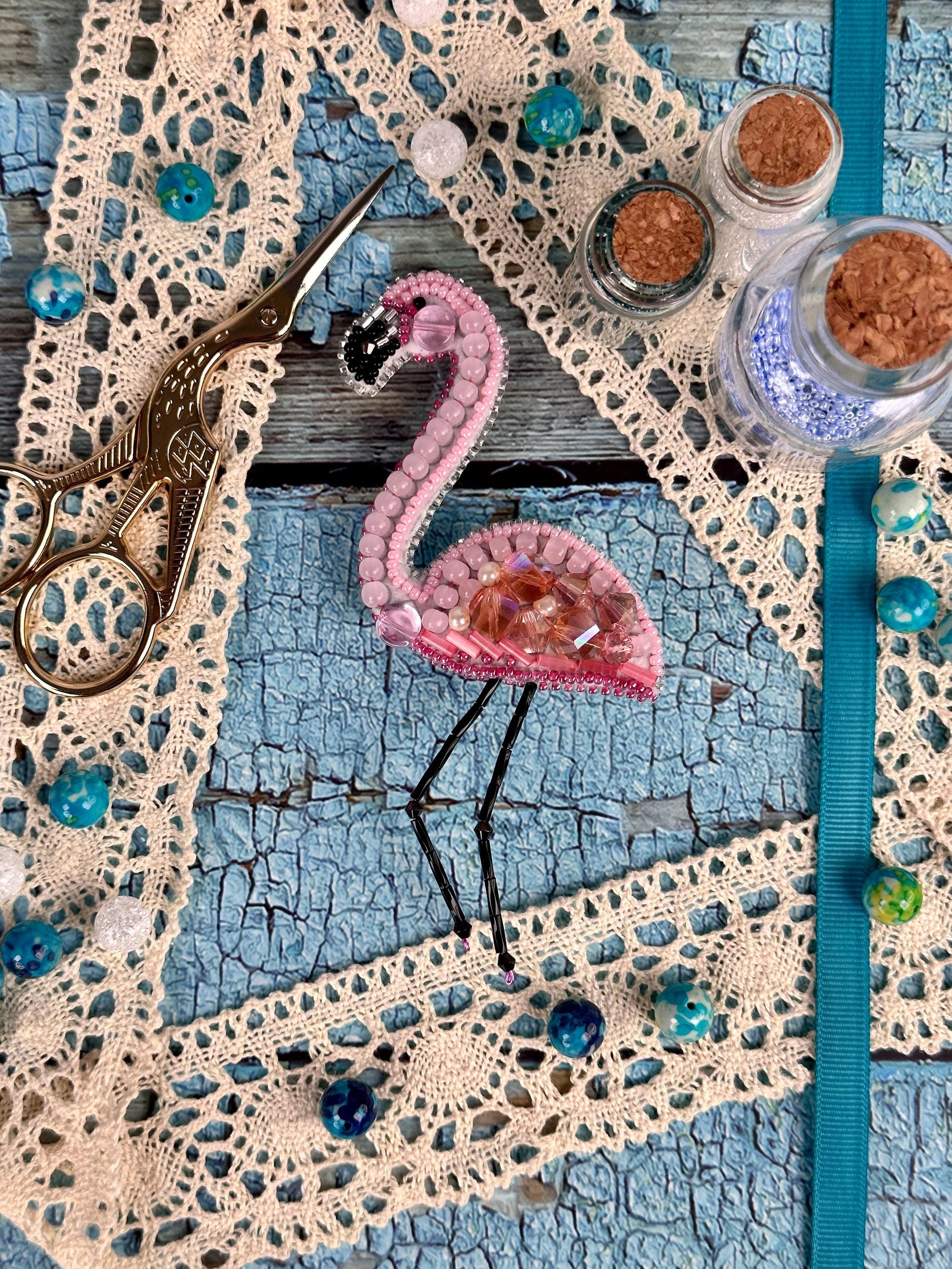 a pink flamingo is sitting on a piece of lace
