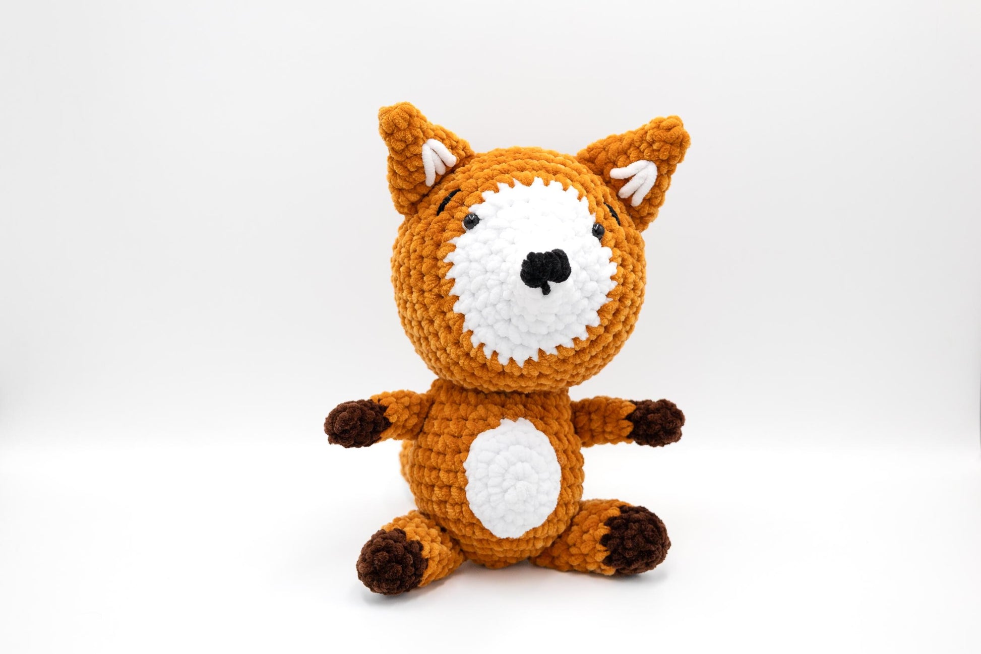 a crocheted stuffed animal sitting on a white surface