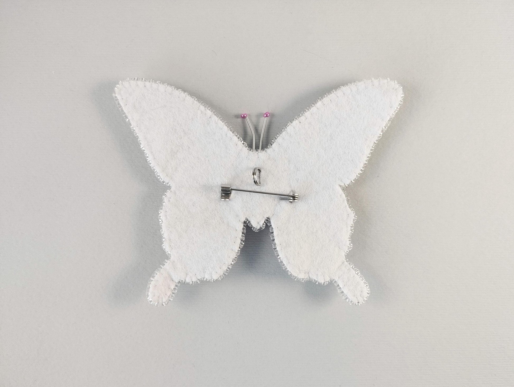 a white clock with a white butterfly on it