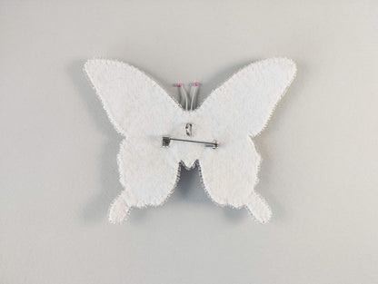 a white clock with a white butterfly on it