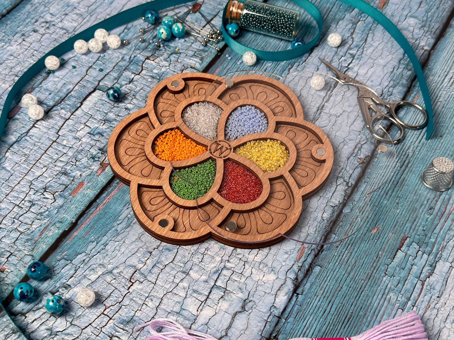 a necklace with a flower design and beads on a table