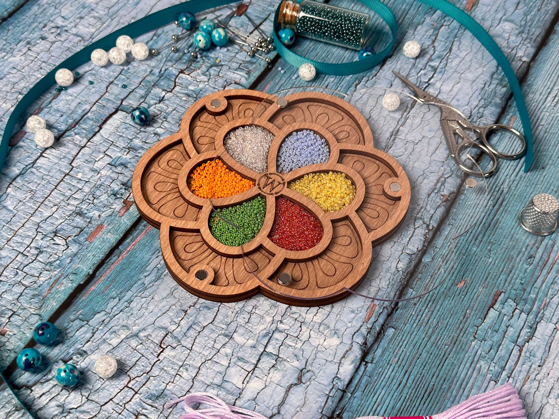 a necklace with a flower design and beads on a table
