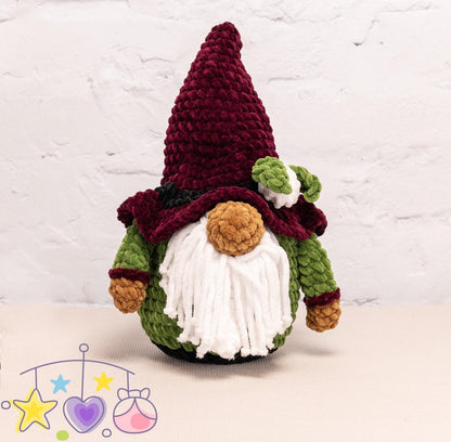 a hand holding a crocheted gnome ornament