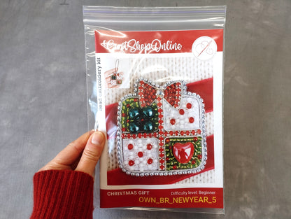 A hand holding a package of a Christmas gift kit, with a picture of the kit on the front.