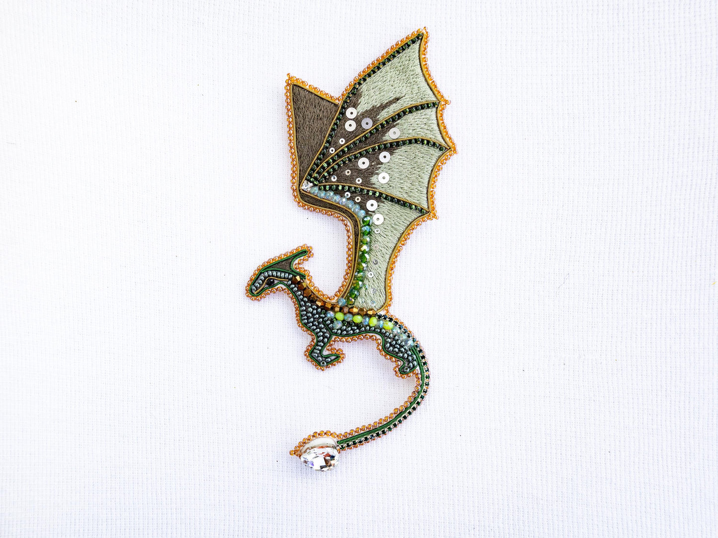 a green dragon embroidered onto a white shirt