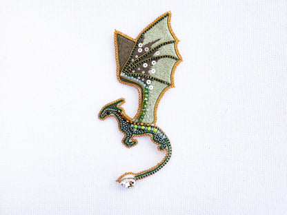 a green dragon embroidered onto a white shirt