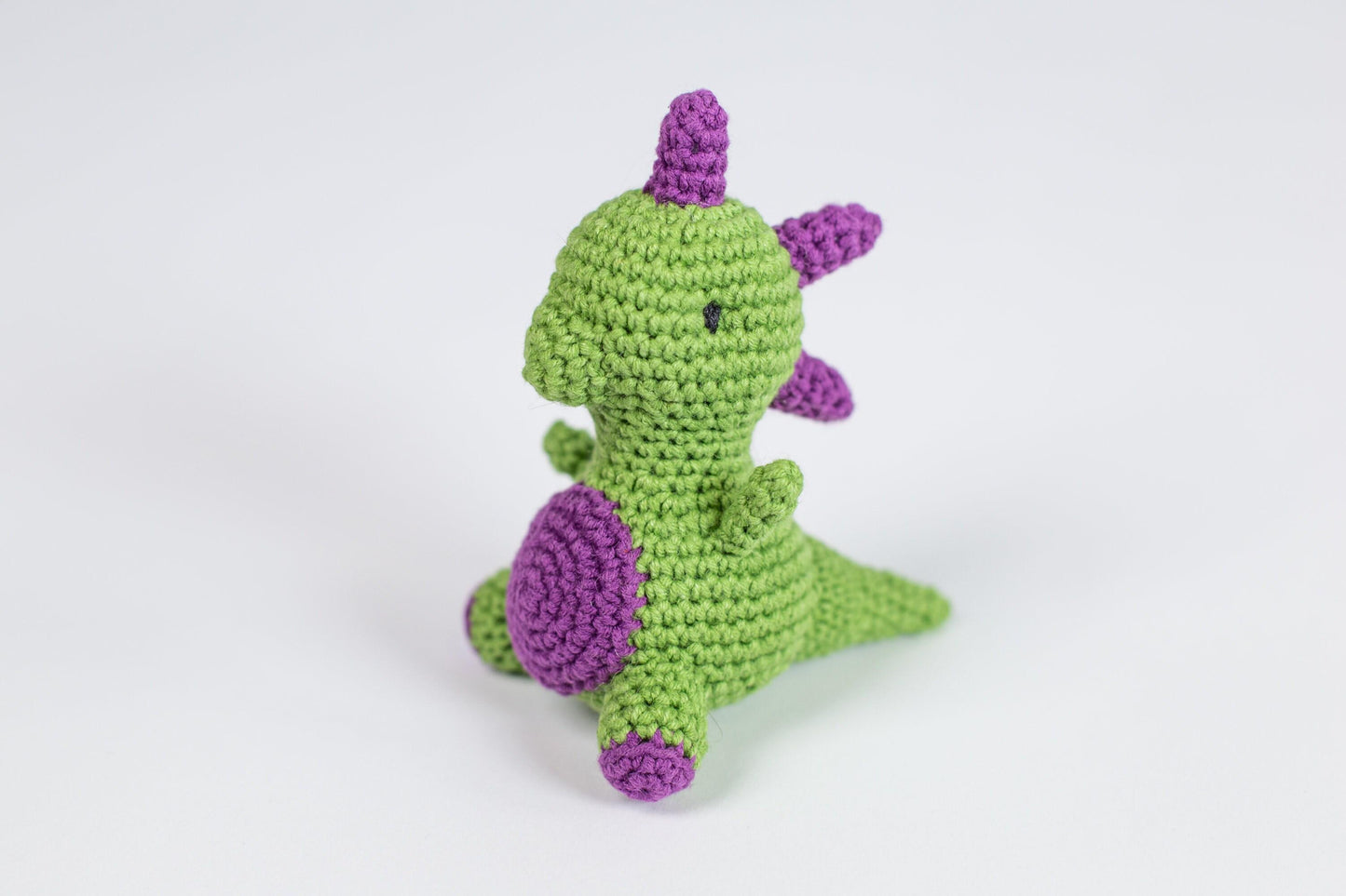 a crocheted green and purple stuffed animal