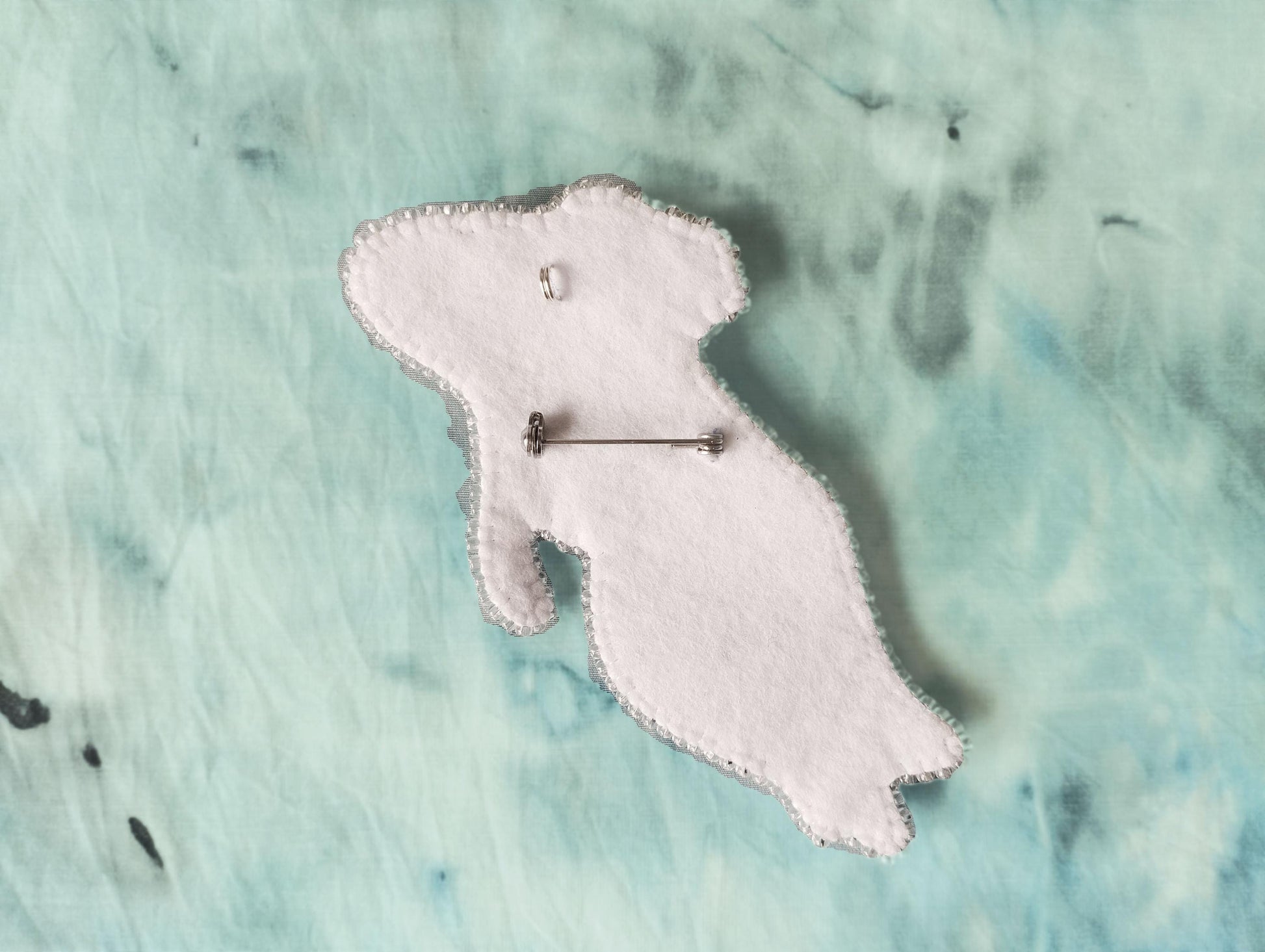 a white piece of fabric with a pin on it