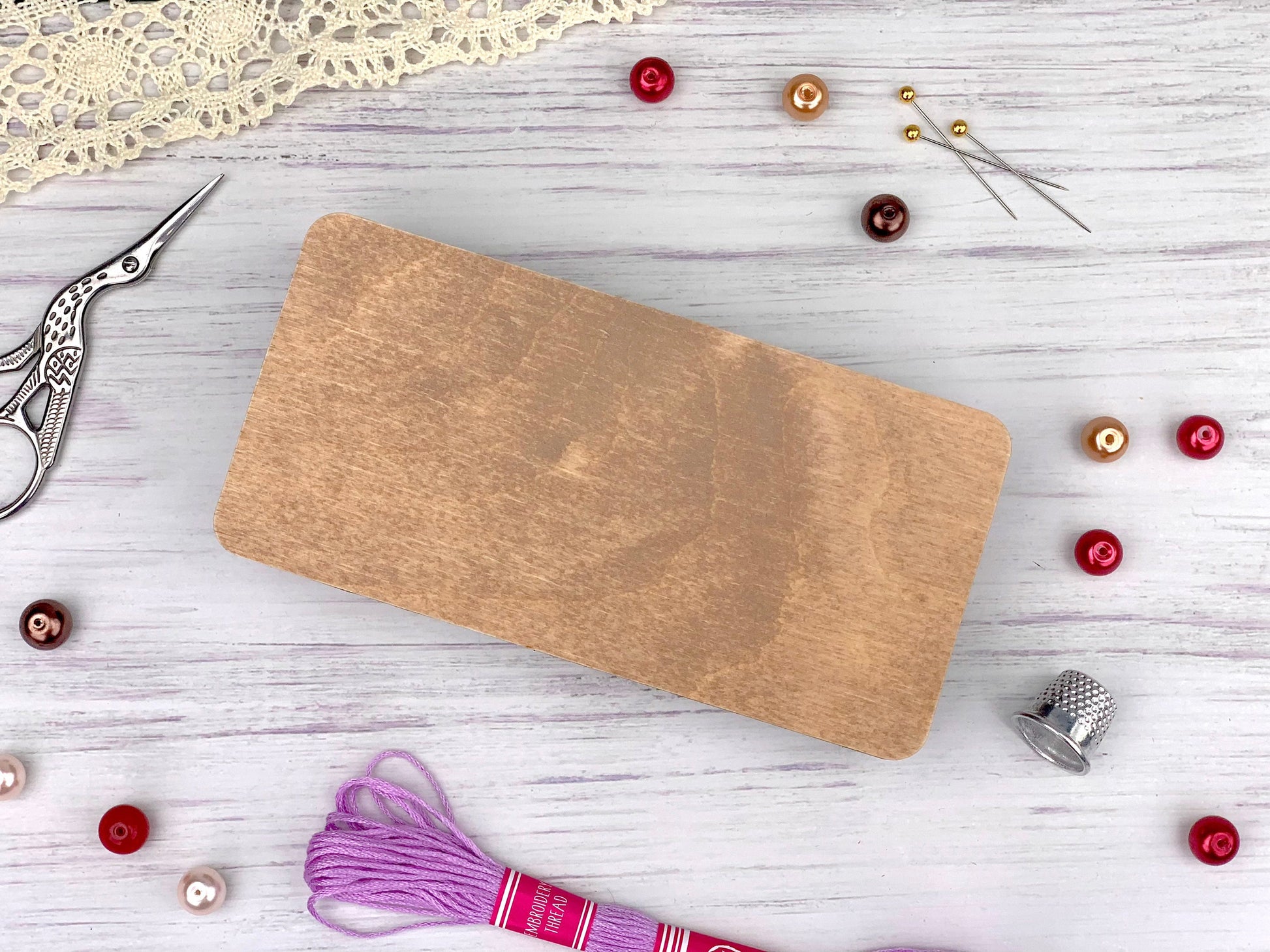 a wooden cutting board sitting on top of a table next to a pair of scissors