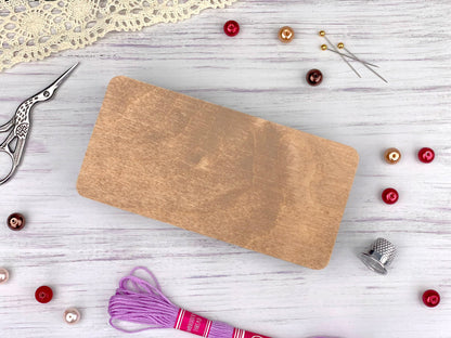 a wooden cutting board sitting on top of a table next to a pair of scissors