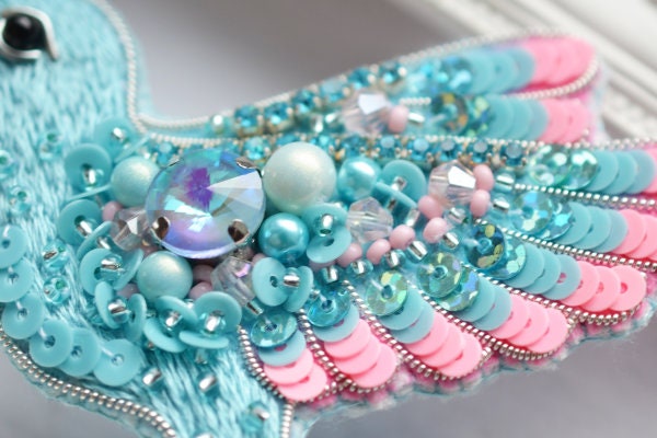 a close up of a bird made of beads and beads