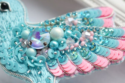 a close up of a bird made of beads and beads