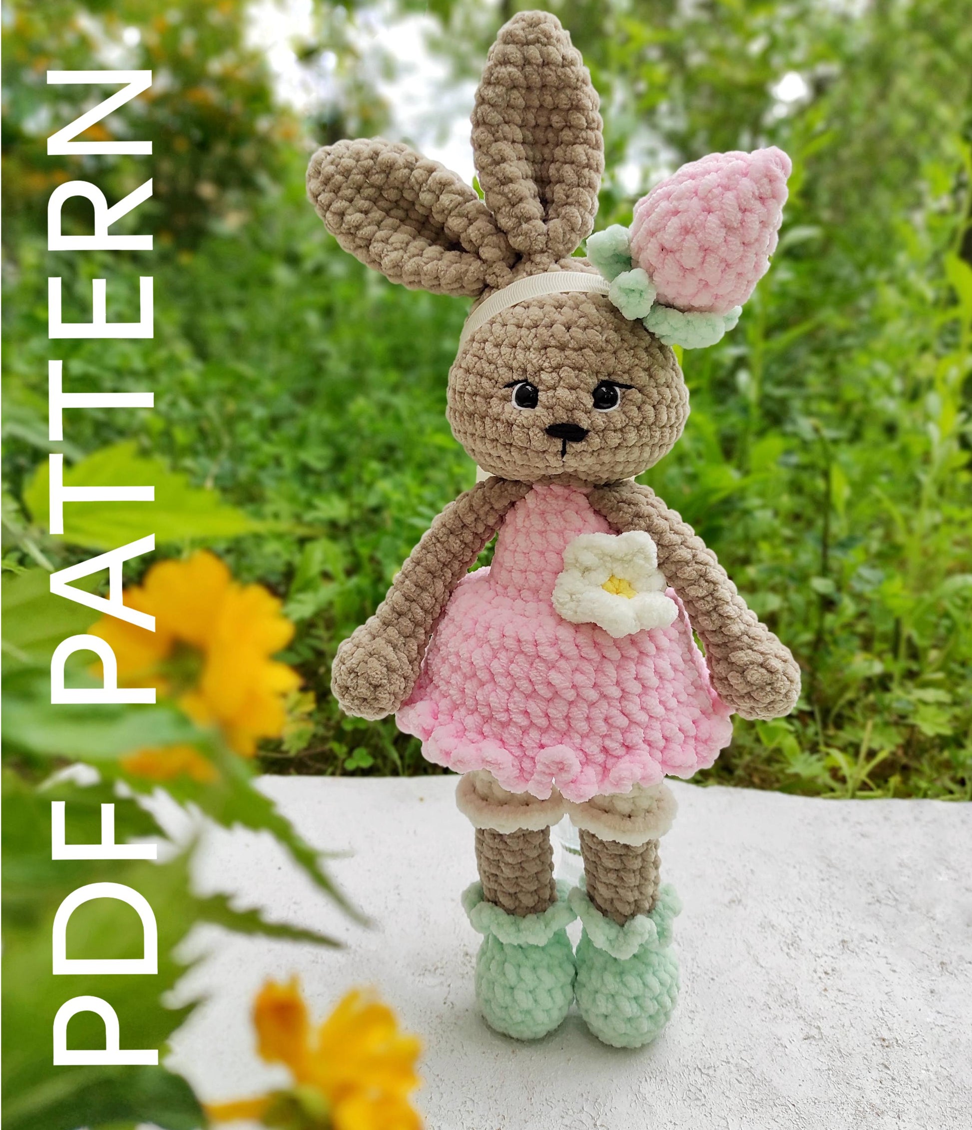 a crocheted bunny doll with a flower in her hand