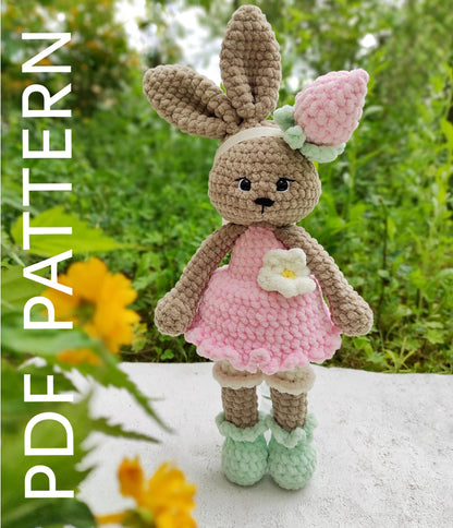 a crocheted bunny doll with a flower in her hand