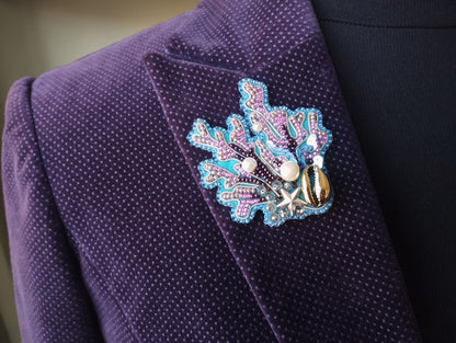 A close-up view of a purple suit jacket with a decorative pin or brooch on the left side.