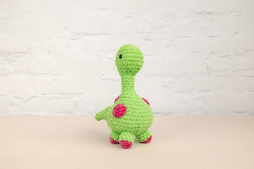 a crocheted green turtle sitting on a table