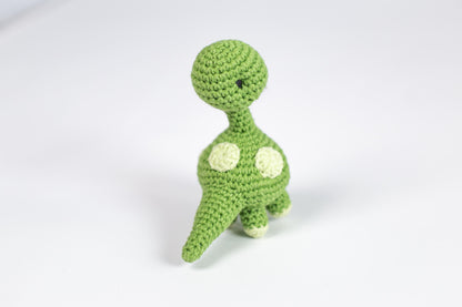 a crocheted toy of a green dinosaur