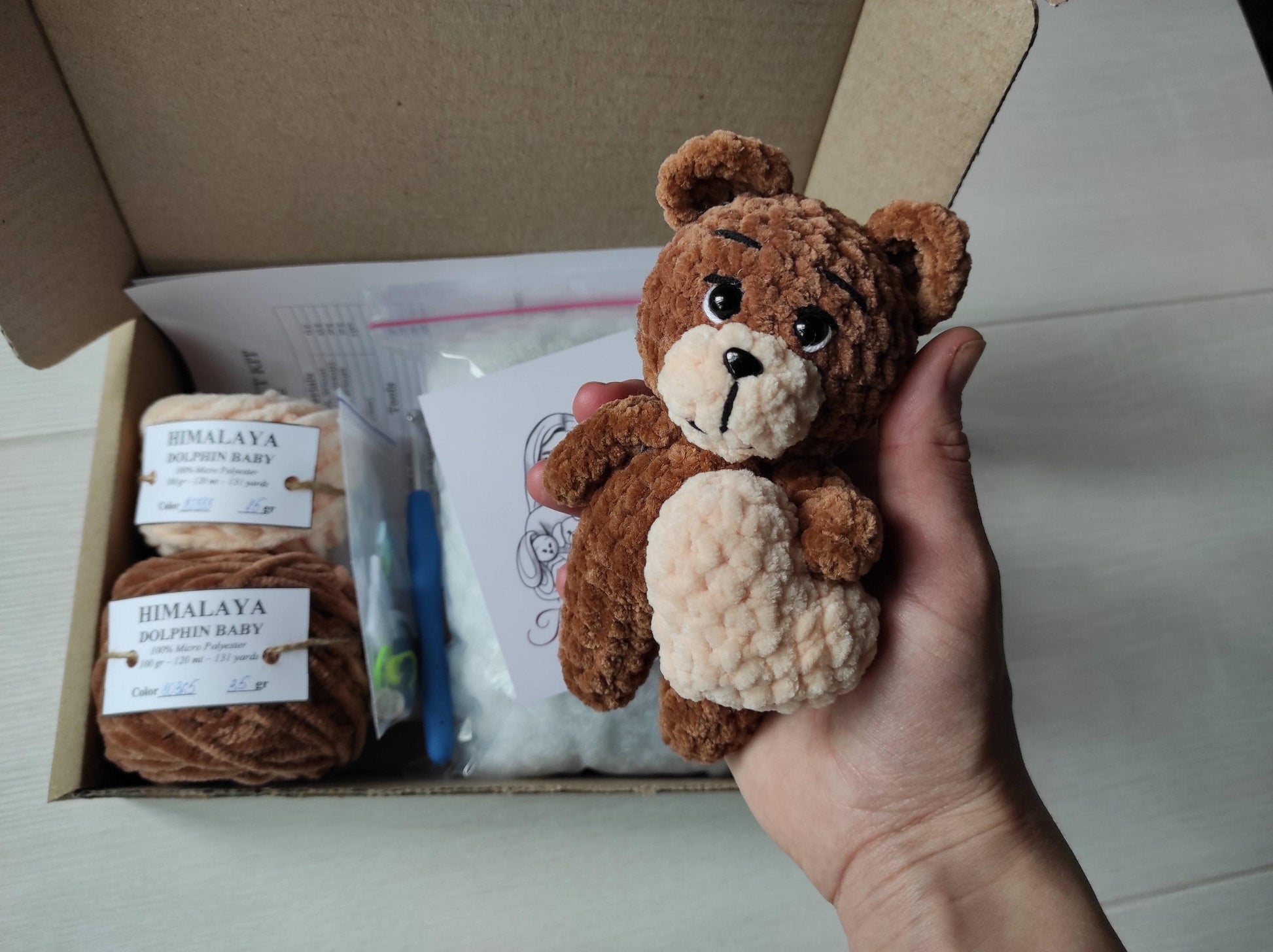 a person holding a stuffed animal in a box