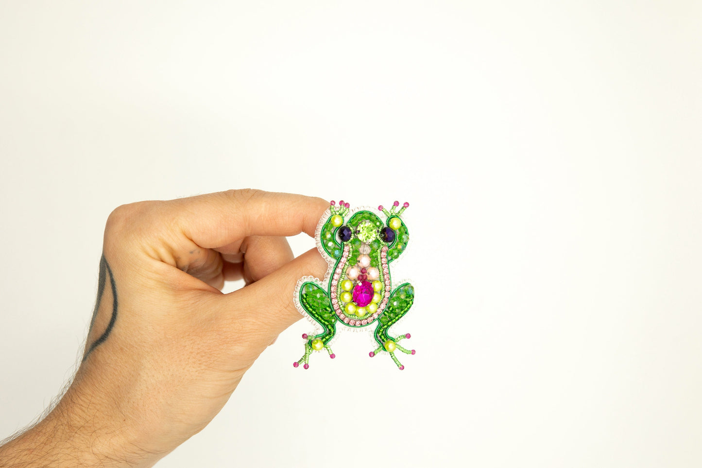 a hand holding a sticker with a frog on it