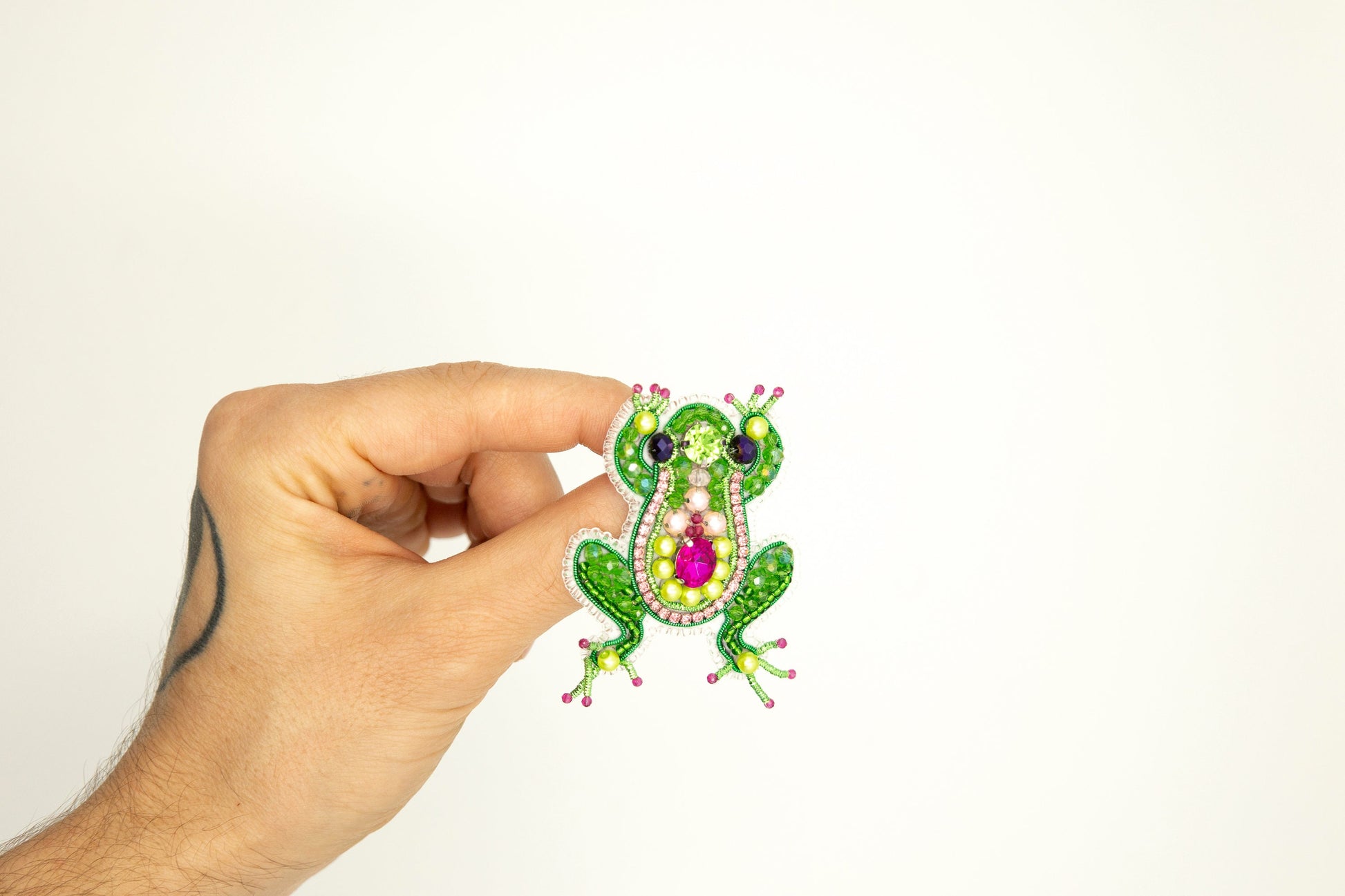 a hand holding a sticker with a frog on it