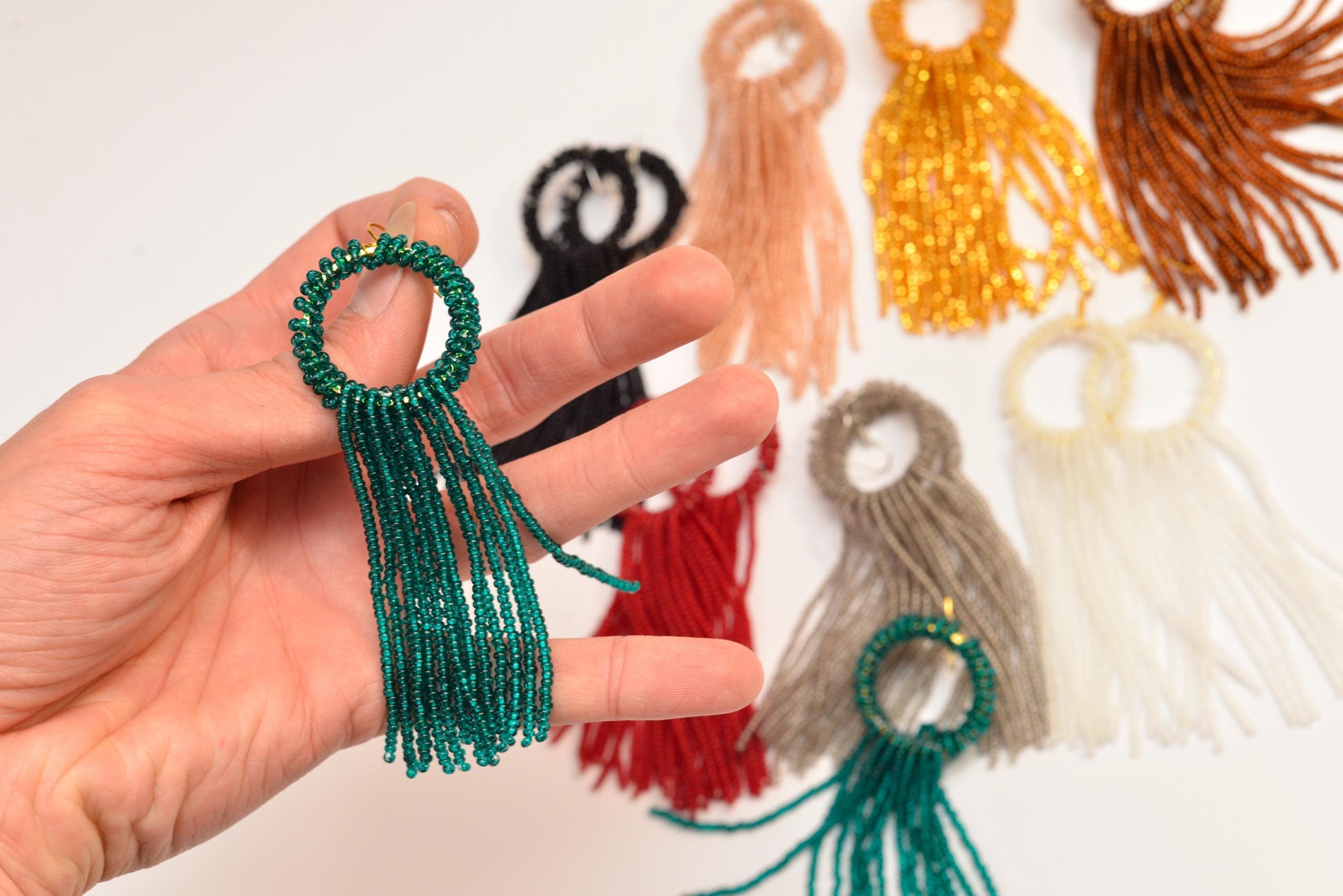 a hand holding a bunch of different colored tassels