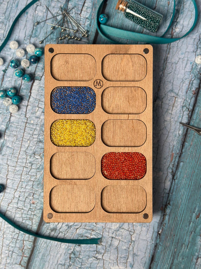 a wooden box with different colored beads in it