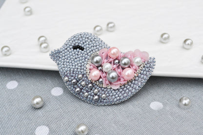 a brooch with pearls and pink flowers on it