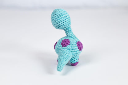 a crocheted toy elephant with a pink and purple nose