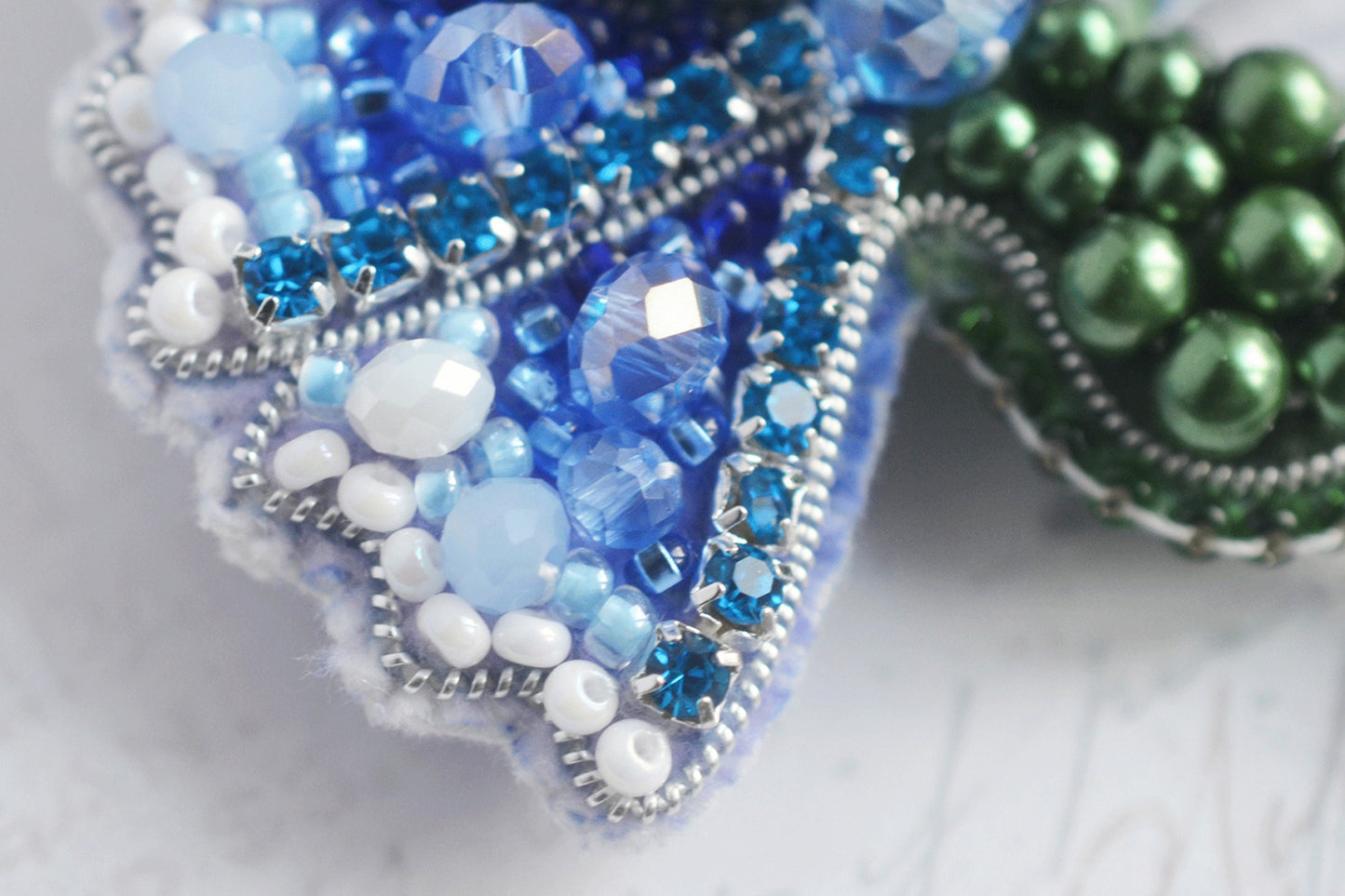 a close up of a brooch with beads on it