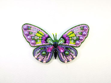 a colorful butterfly made out of beads on a white surface