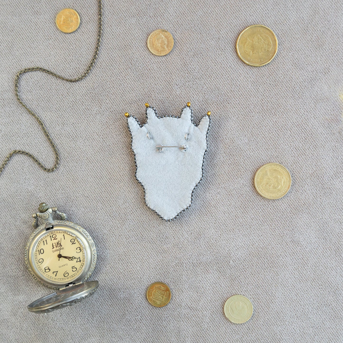 a pocket watch and a necklace with a picture of a cat on it