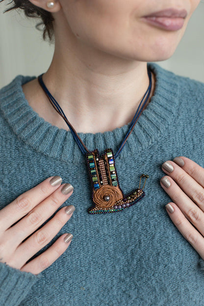 a woman wearing a necklace with a bird on it