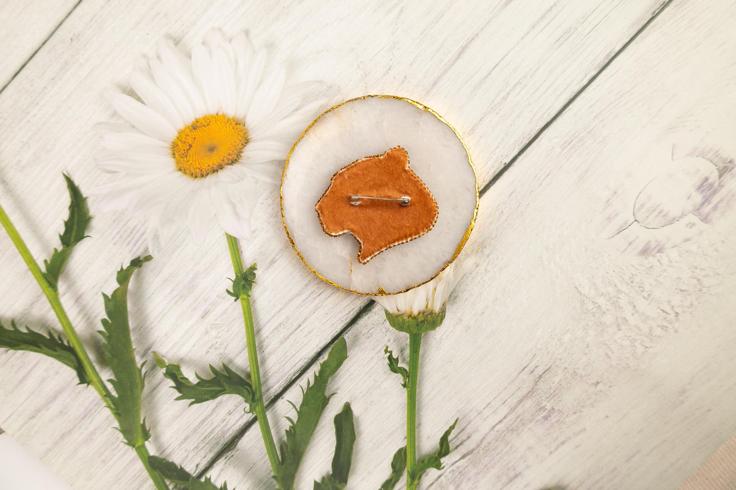 a flower and a brooch sitting on a table