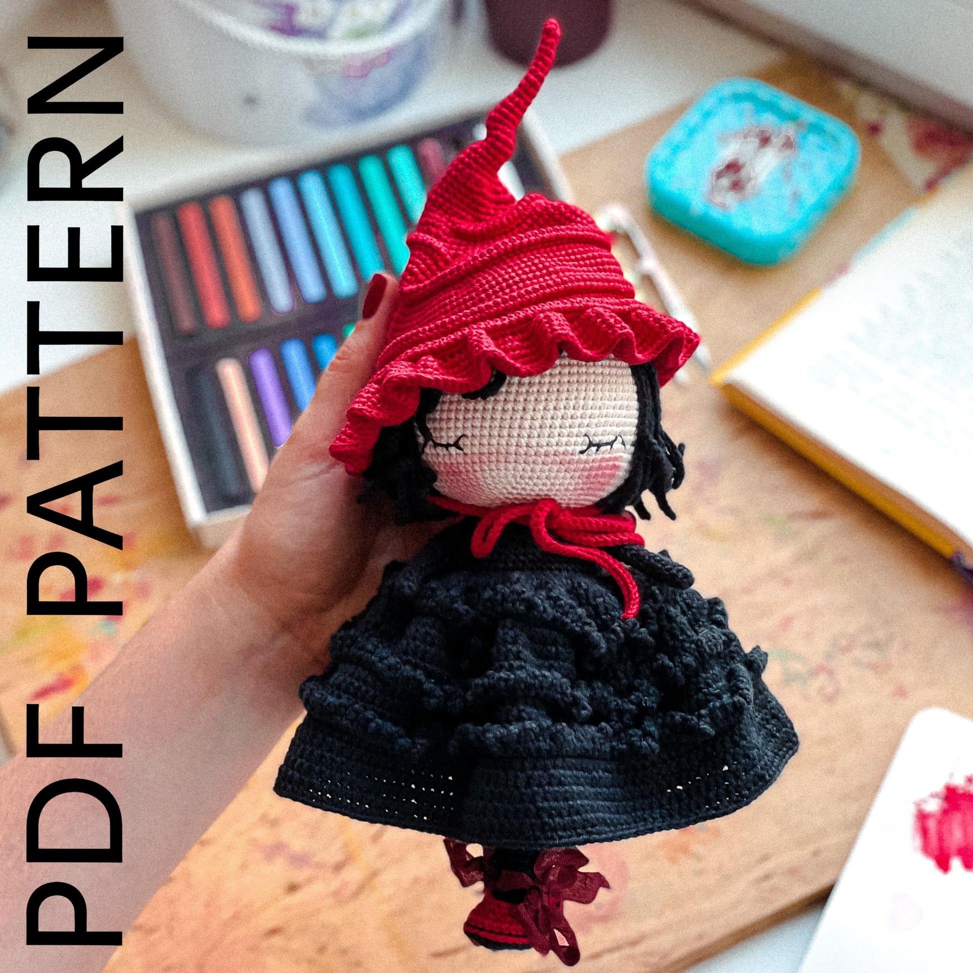 a hand holding a doll with a red hat