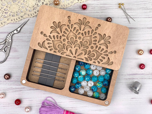 a wooden box filled with beads and a pair of scissors