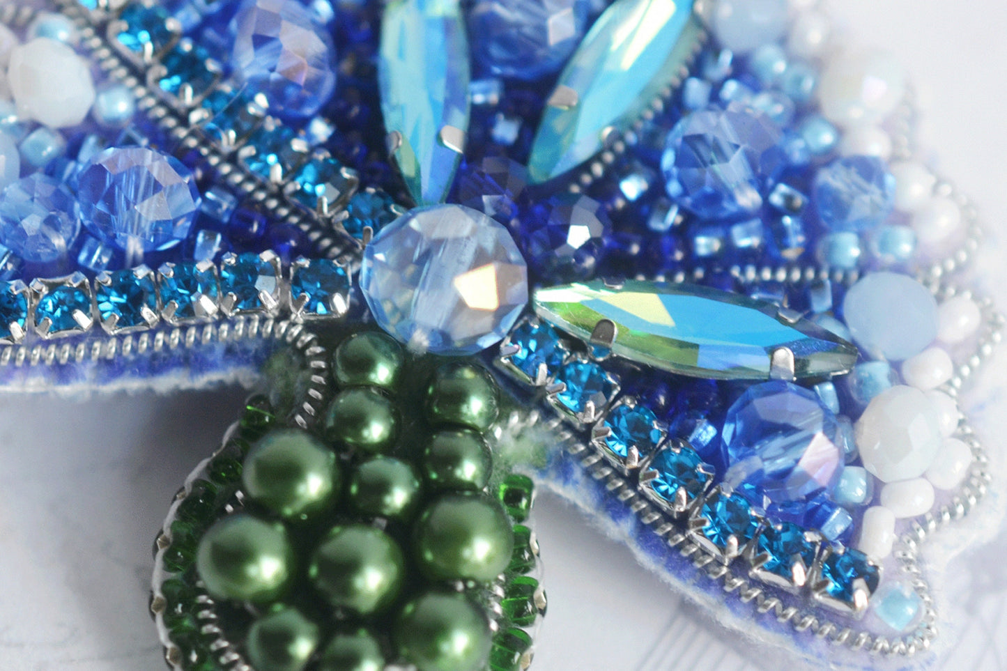 a close up of a brooch with beads on it