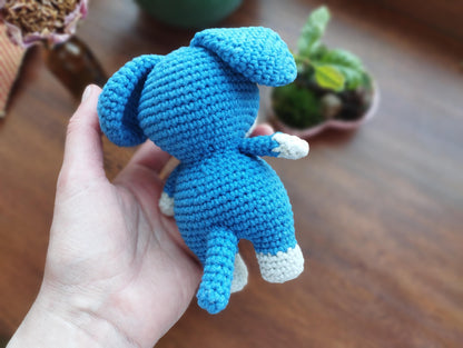 a hand holding a small crocheted stuffed animal